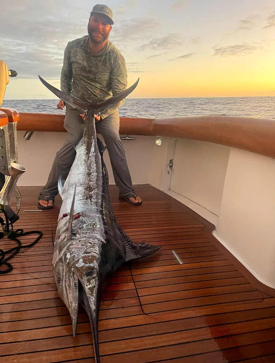 Un pêcheur avec un marlin bleu récolté.
