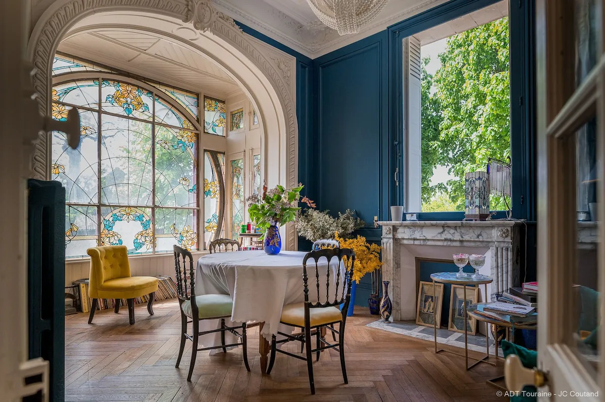 La deuxième salle à manger possède des fenêtres et des moulures ornées ainsi qu'une cheminée en marbre.