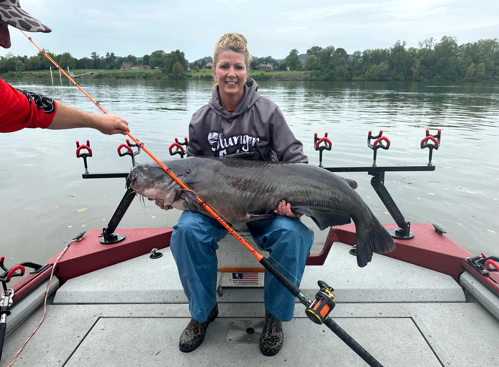 Un pêcheur à la ligne avec un gros poisson-chat bleu pêché dans la rivière Ohio.