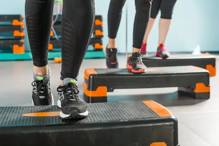 Vue rapprochée des jambes féminines exerçant dans une salle de sport