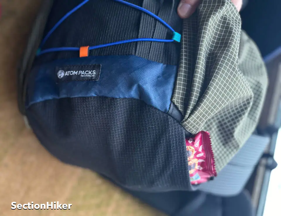 Une poche en maille extensible coule le long de la base du pack et peut être utilisée pour stocker des collations, des déchets ou des chapeaux et des gants.