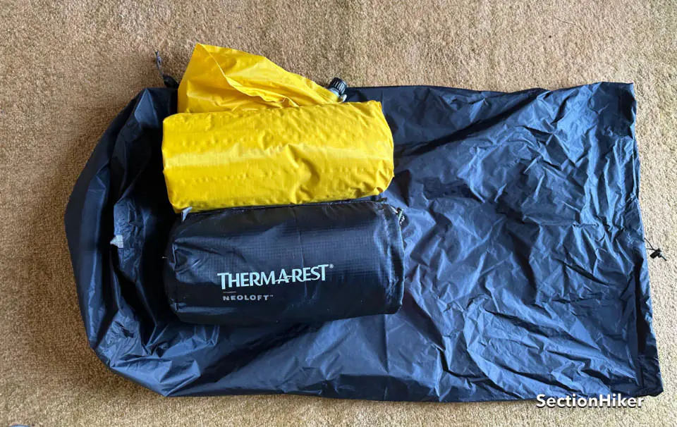 Une comparaison du Neoair Xlite NXT (jaune) et du Neoloft (bleu). Ils sont un bot sur le grand sac de pompe qui accompagne le pad Neoloft.