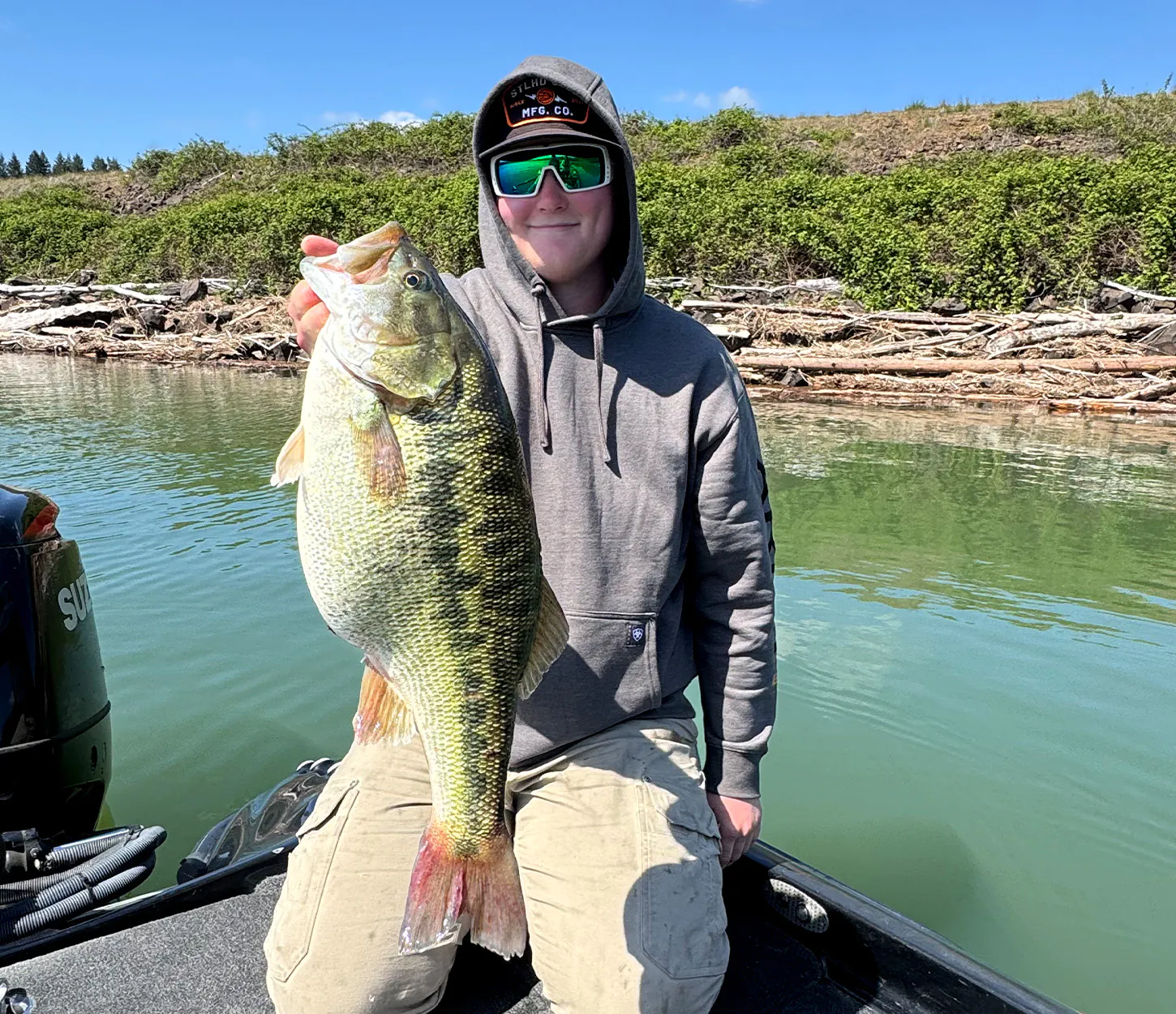 Un pêcheur de basse tient une grosse basse tachetée.