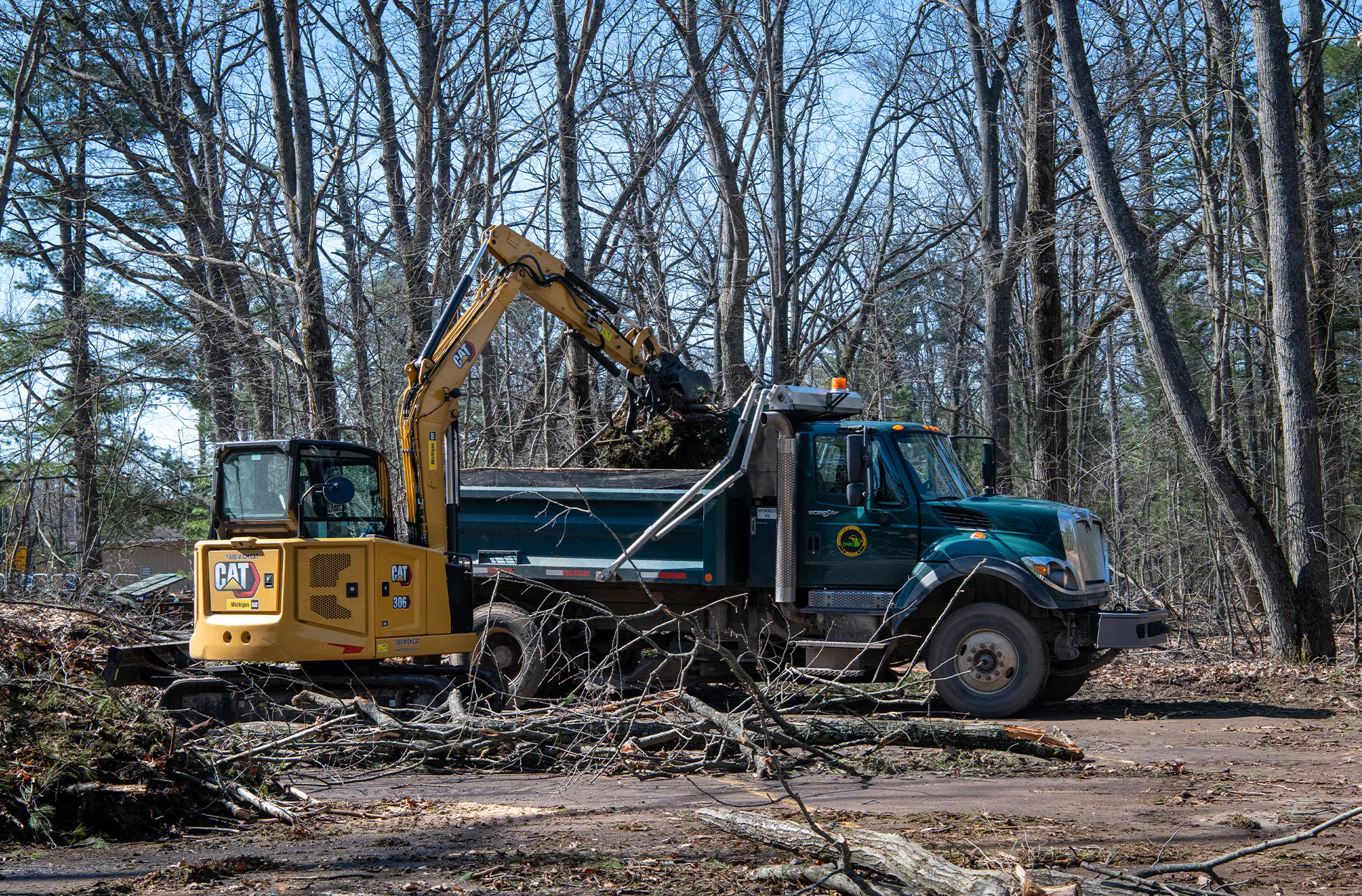 Une équipe d'équipement lourd nettoie une route dans une forêt du Michigan.