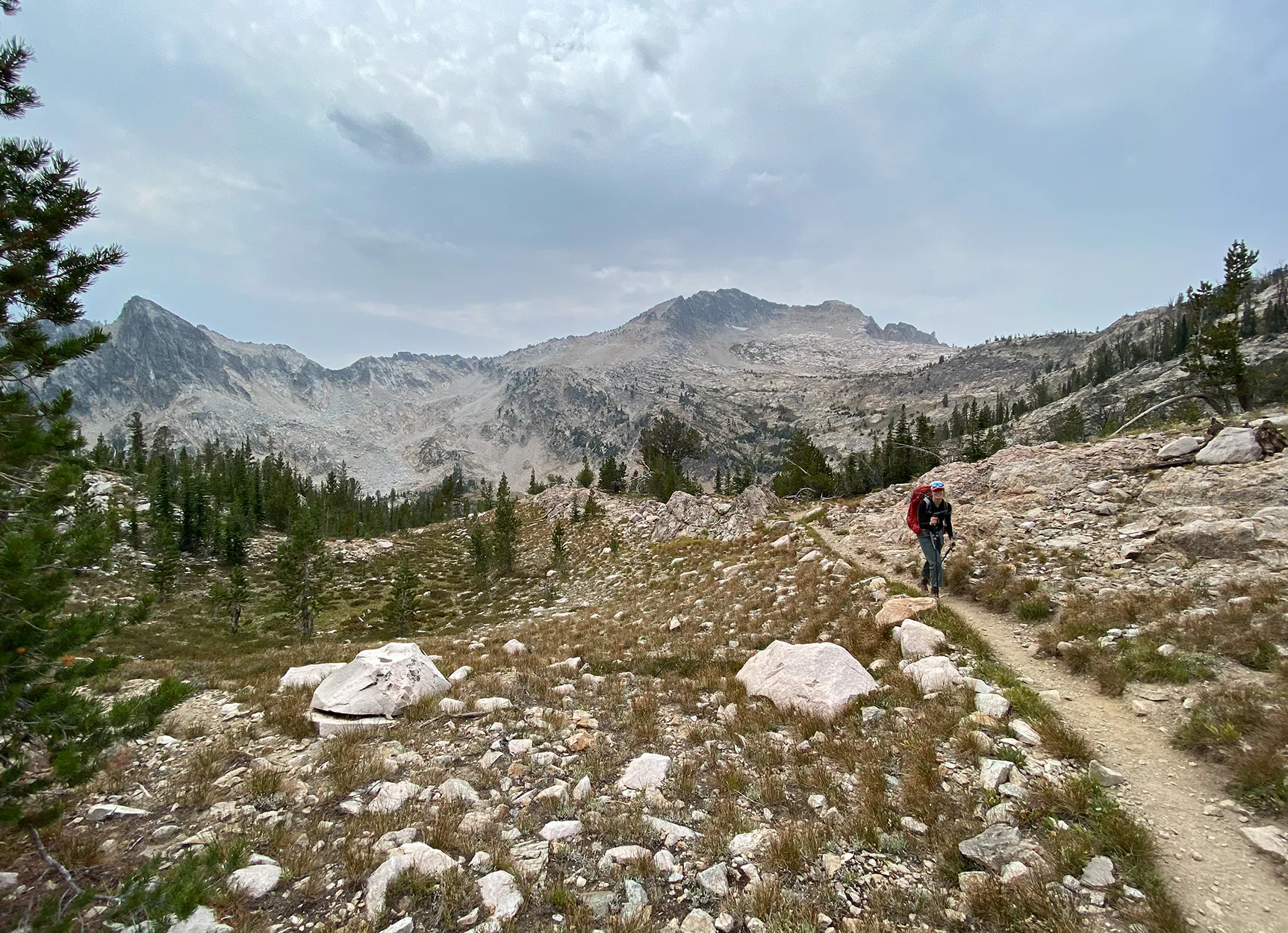 Un routard descend sur un sentier dans les montagnes.