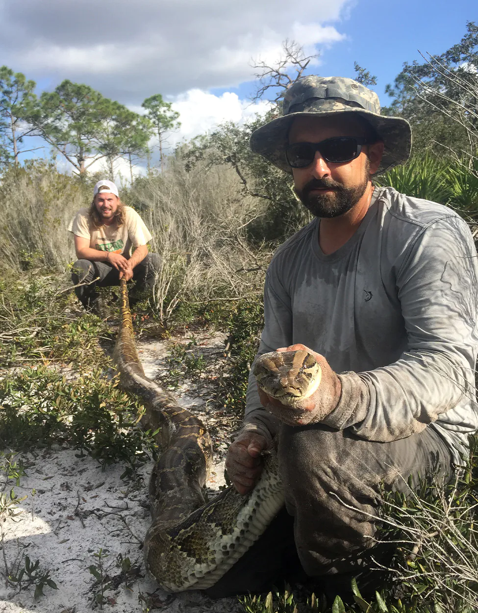 Un tracker python avec un homme "serpent scout" en Floride.