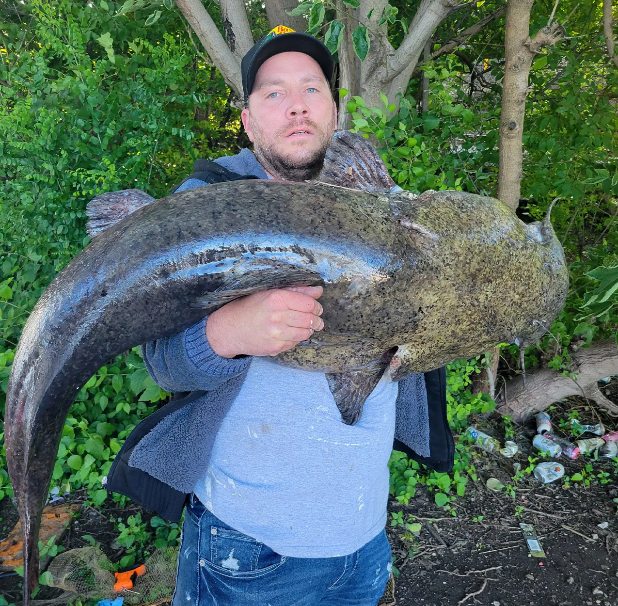 Un pêcheur tient un poisson-chat à tête plate pris à Philadelphie.