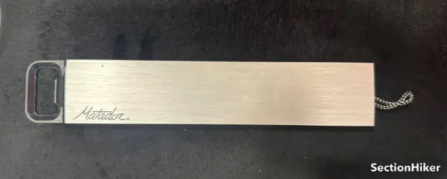 Le manchon en aluminium empêche le cas d'être écrasé, tandis que la longe arrière facilite la fixation à un biner ou à un autre objet.