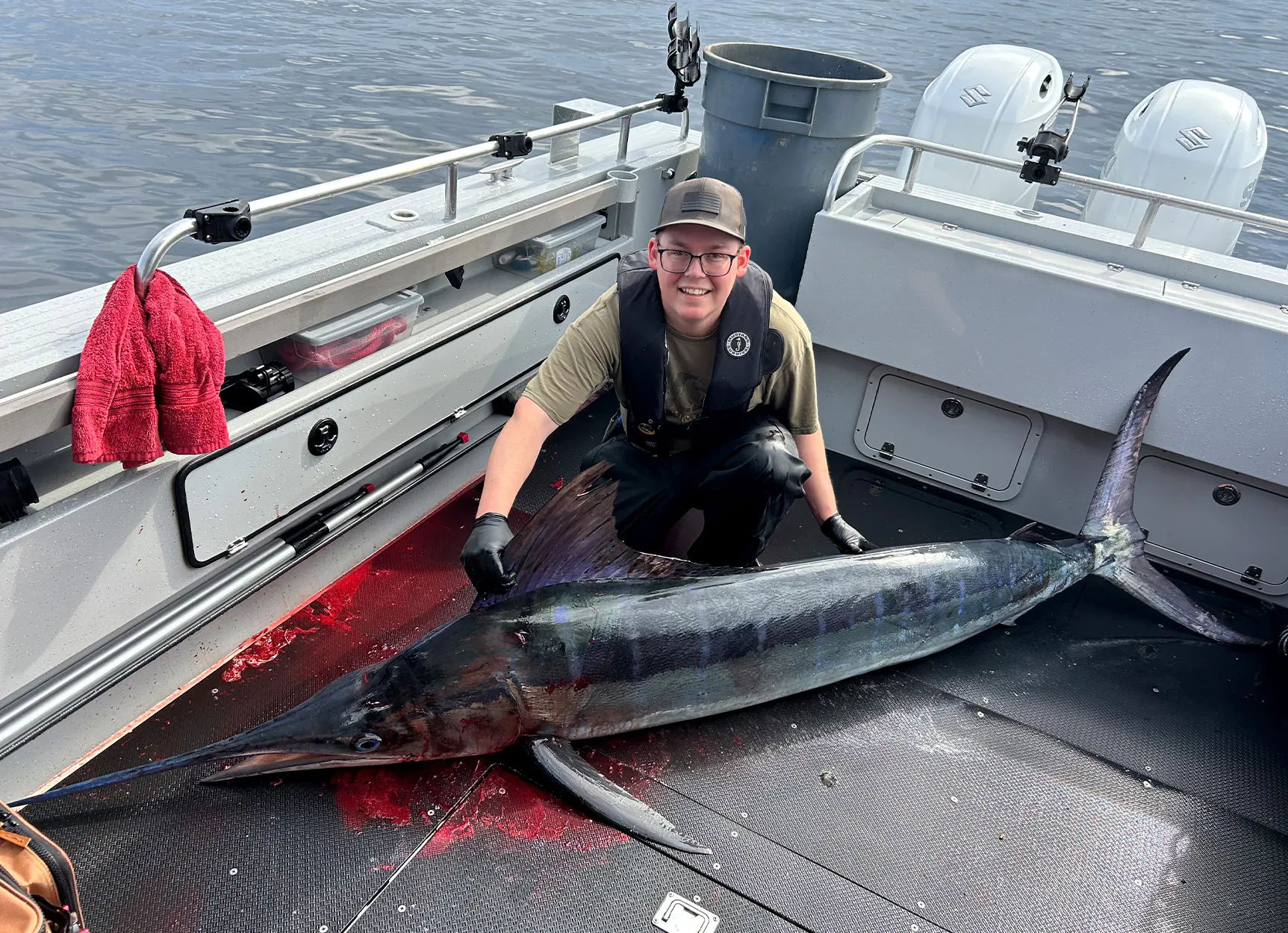 Un pêcheur de l'Oregon avec un marlin rayé rare sur le pont du bateau.