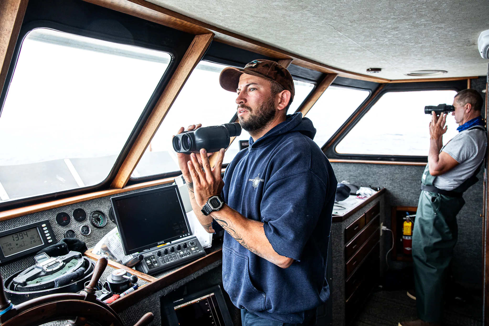 Un capitaine à la tête d'un navire charter scouts pour le poisson.