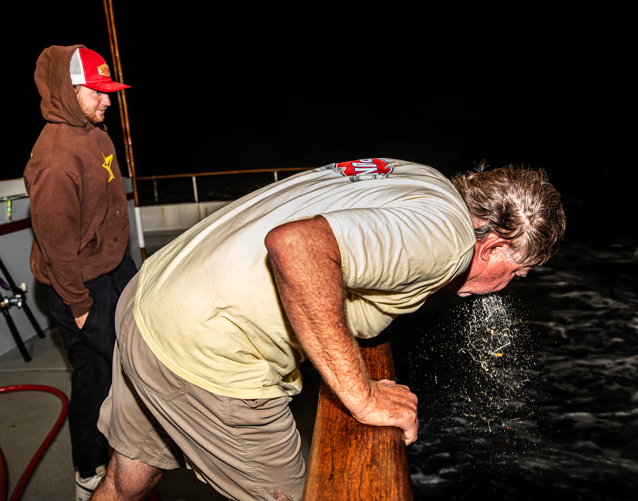 Un homme pukes sur le côté d'un bateau.