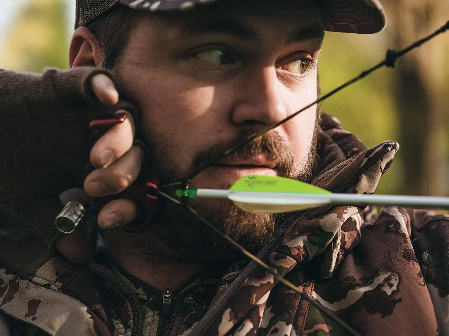 Un chasseur se retire sur un arc composé.