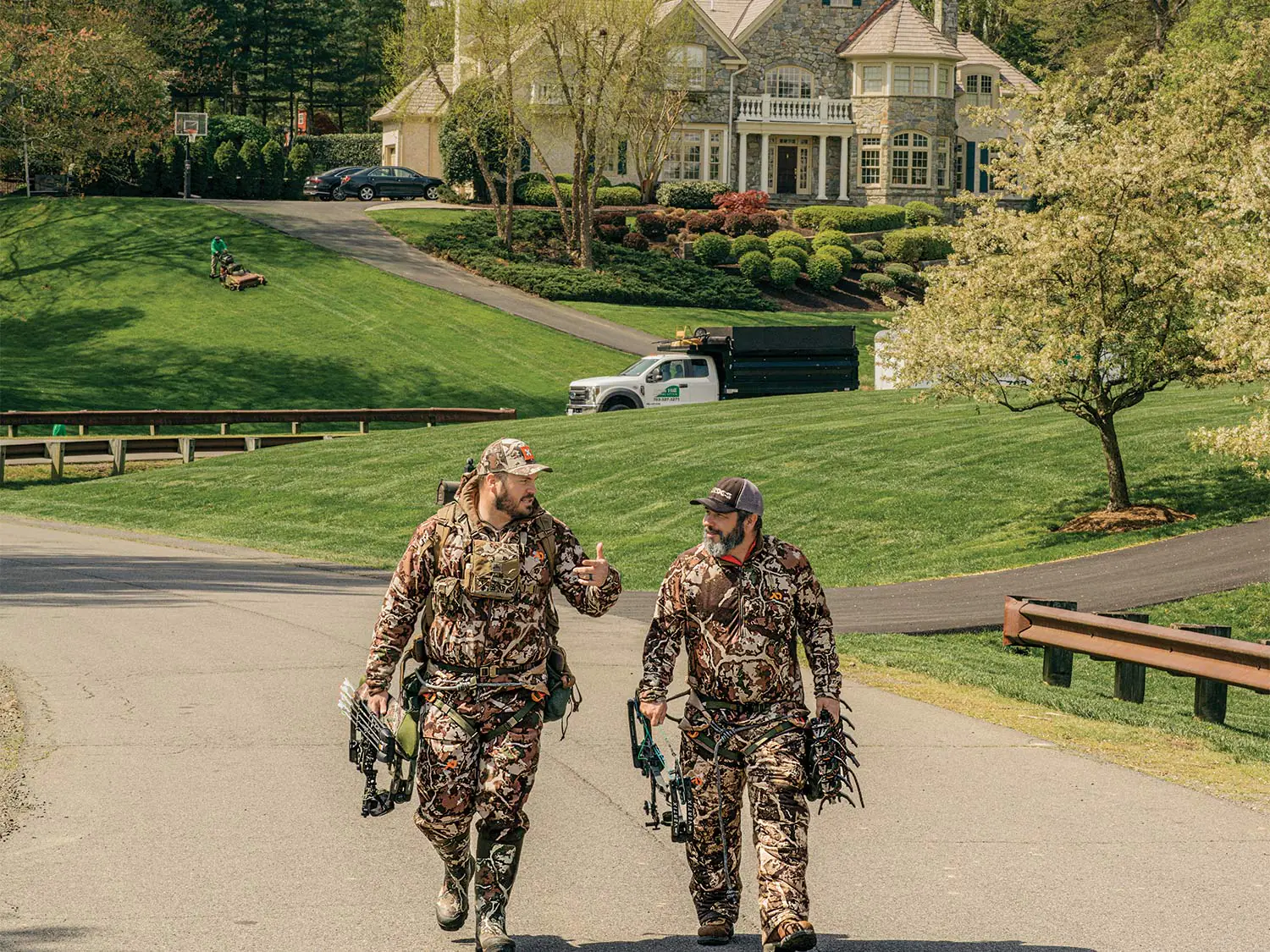 Deux chasseurs en camouflage complet marchent dans la rue au milieu des banlieues de Virginie.