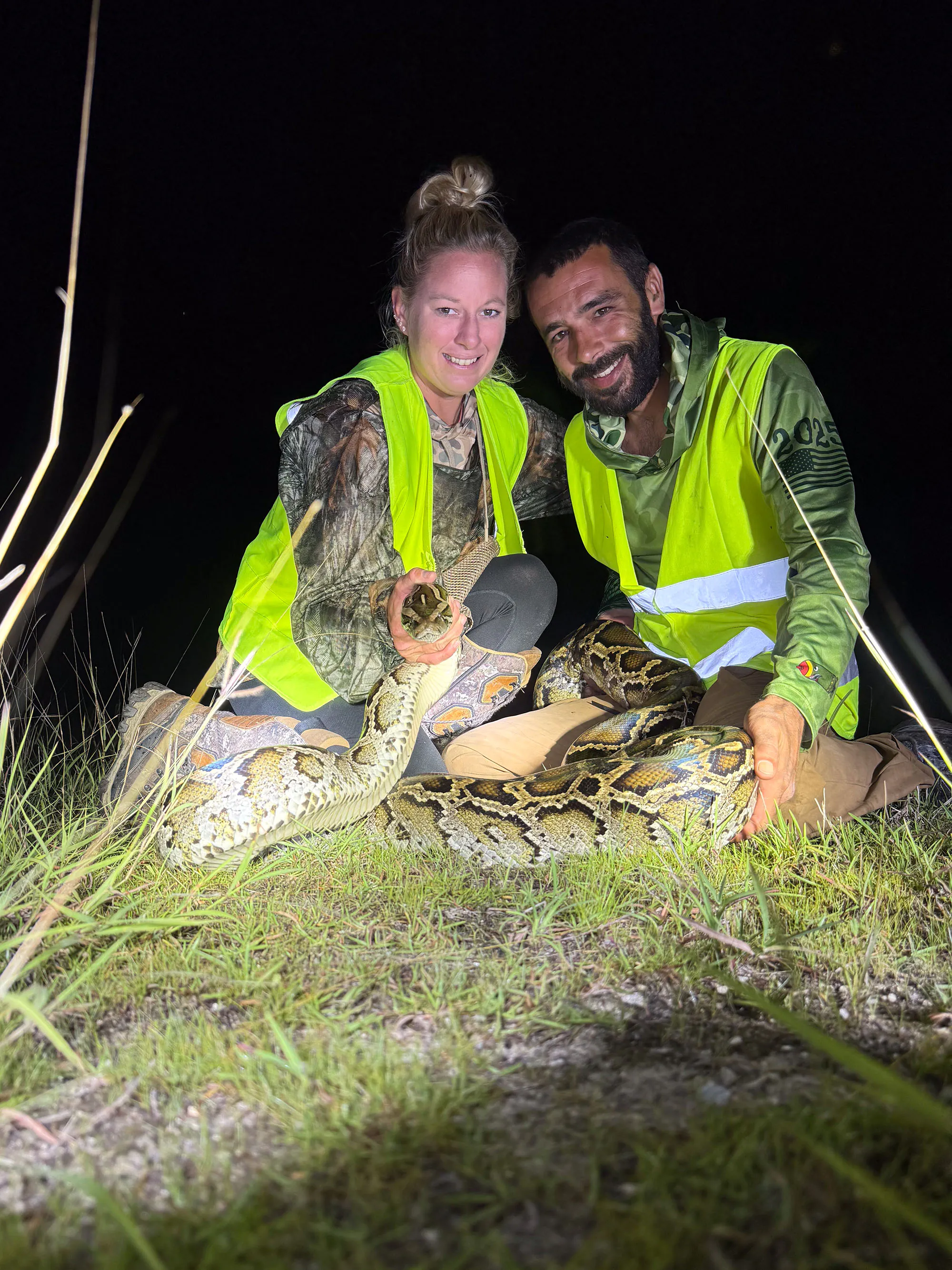 Deux entrepreneurs Python occupent un grand python qu'ils ont pris dans l'obscurité.