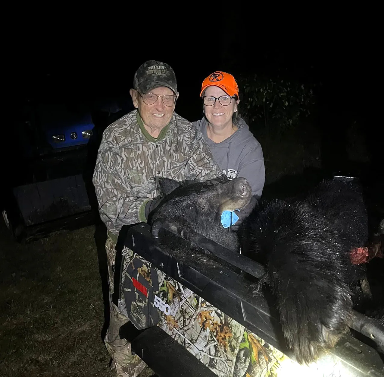 Un chasseur et un ami avec l'ours noir qu'ils ont récupéré.