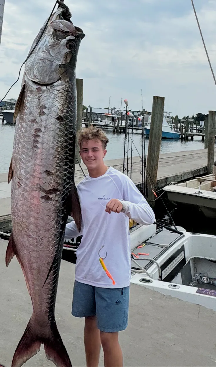 Un adolescent de Louisiane se dresse à côté d'un tarpon géant sur la balance.