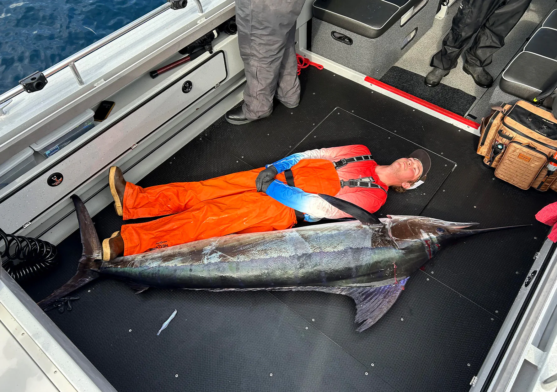 Un pêcheur est à côté d'un gros marlin pour l'échelle.