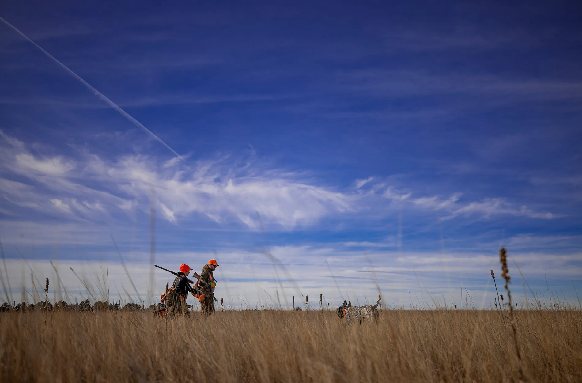 Deux chasseurs d'oiseaux et un chien dans la prairie du Nebraska.
