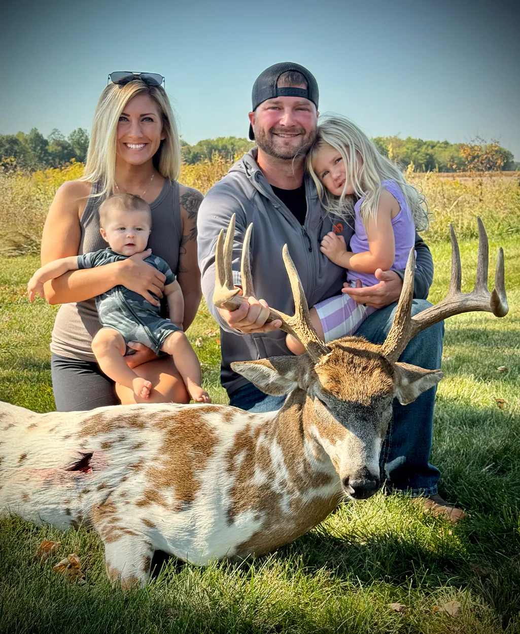 Un chasseur et sa famille posent avec un cerf.