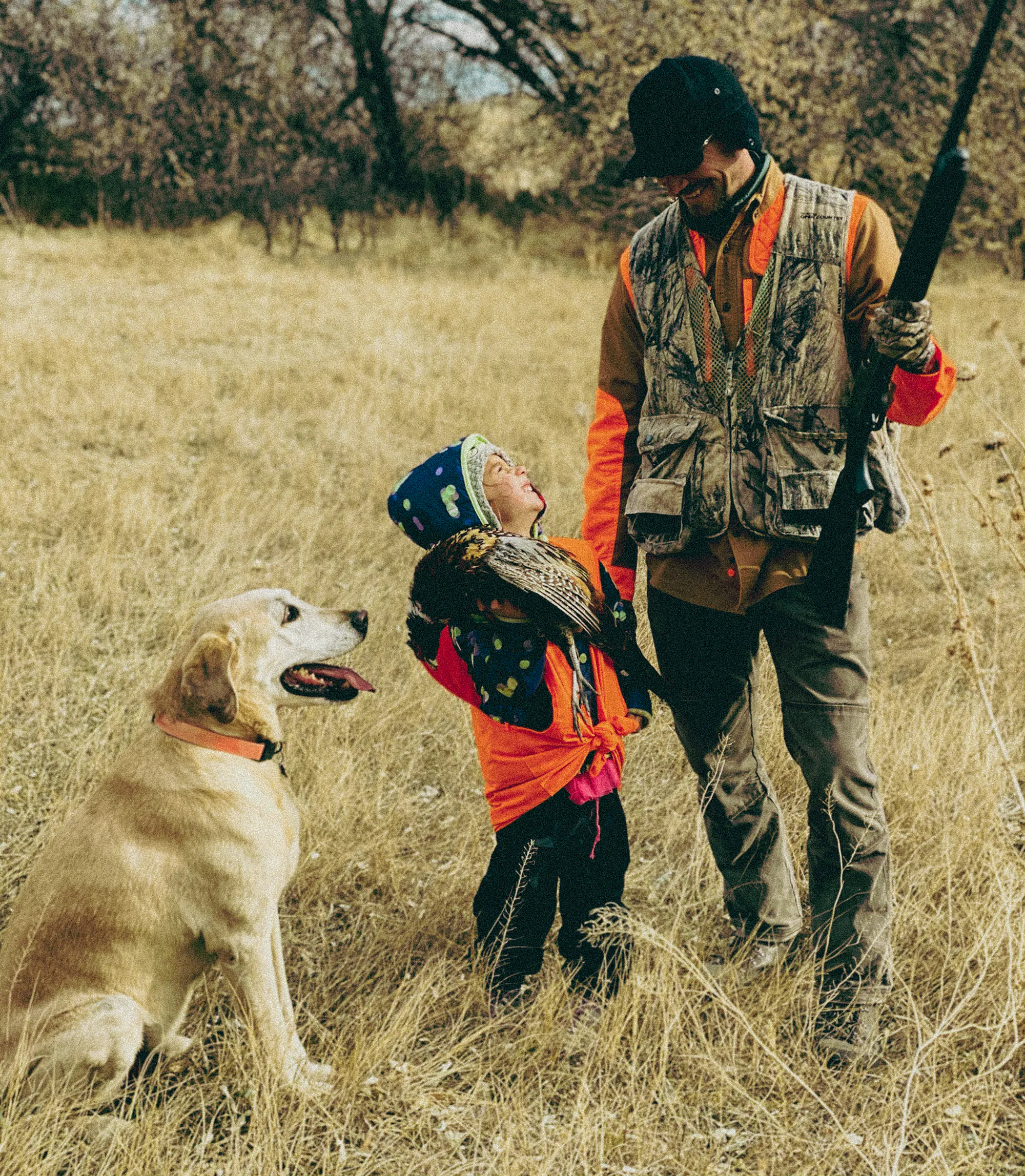 Un père et sa fille et un chien chassant le faisan.