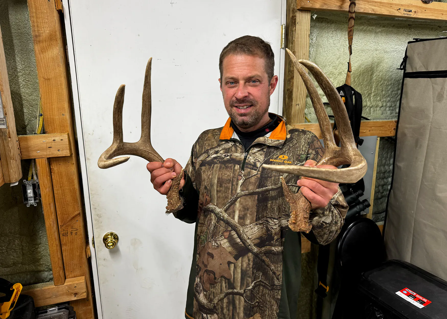 Un chasseur brandit une paire de bois de cerf à queue blanche.