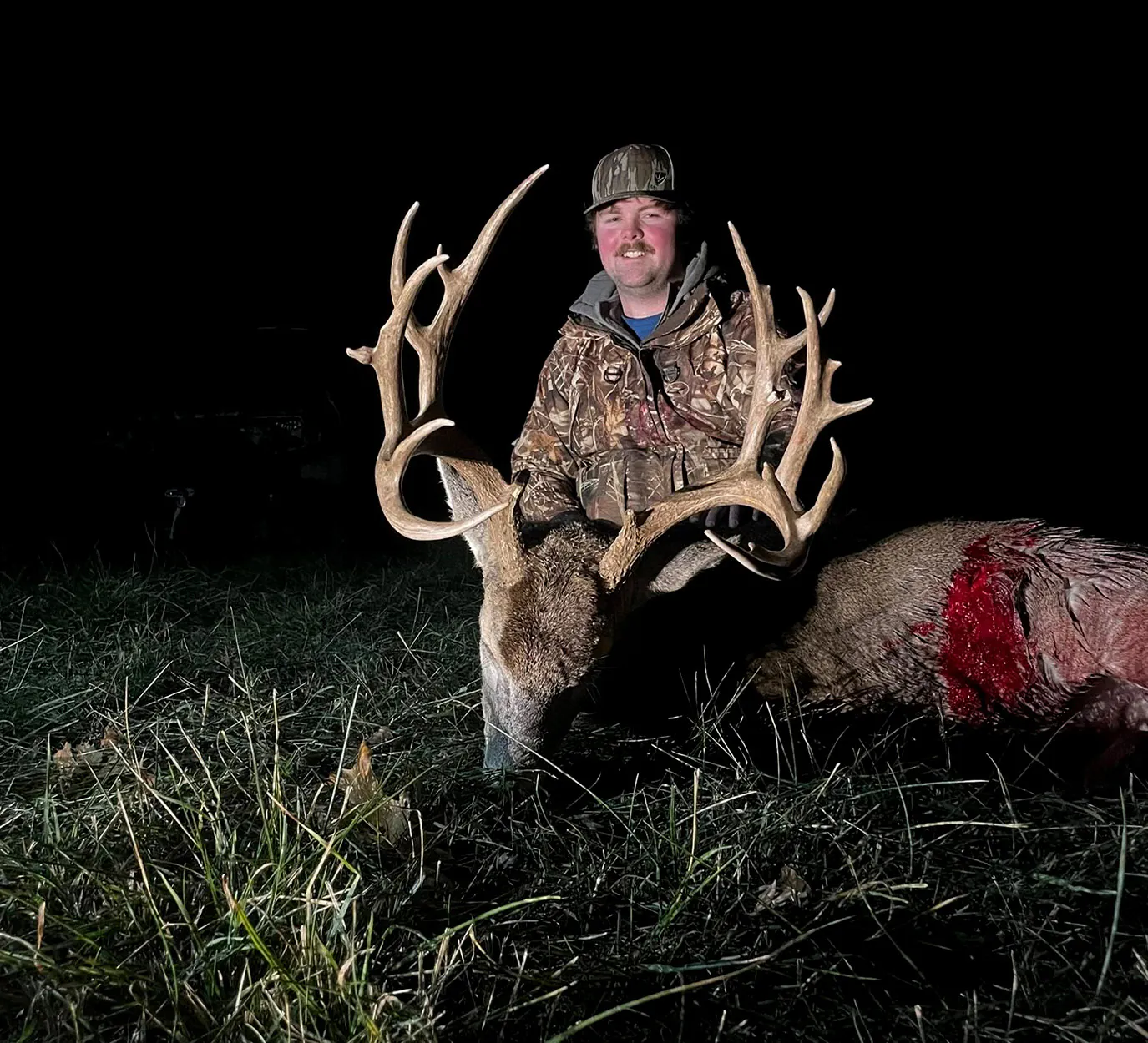 Un chasseur à l'arc s'agenouille avec un gros mâle du Missouri.