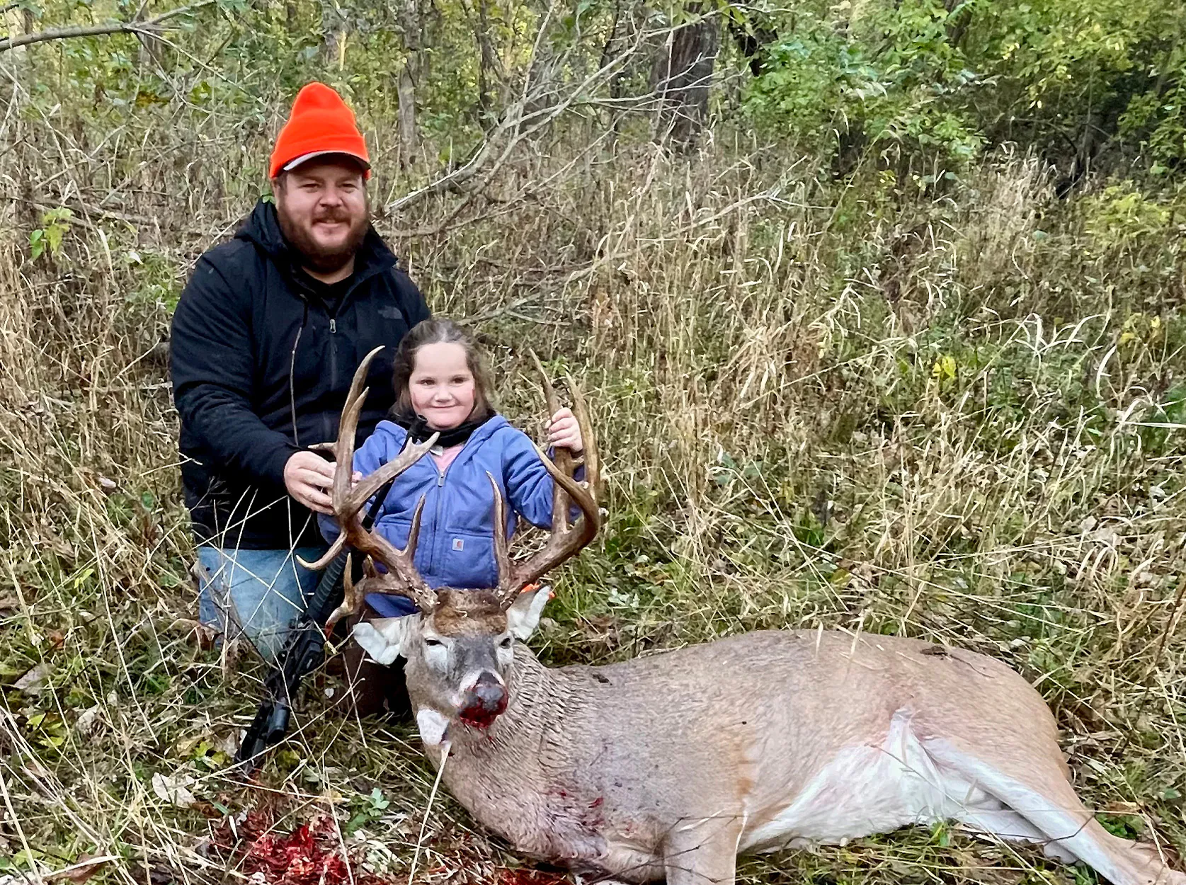Une jeune chasseuse et son papa avec son premier cerf.