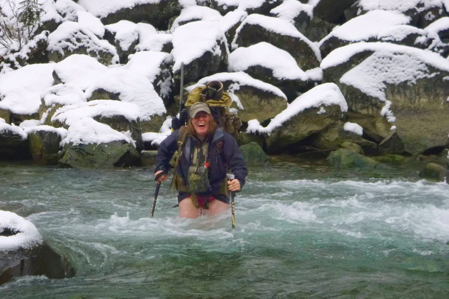 femme traversant de l'eau glaciale à gué