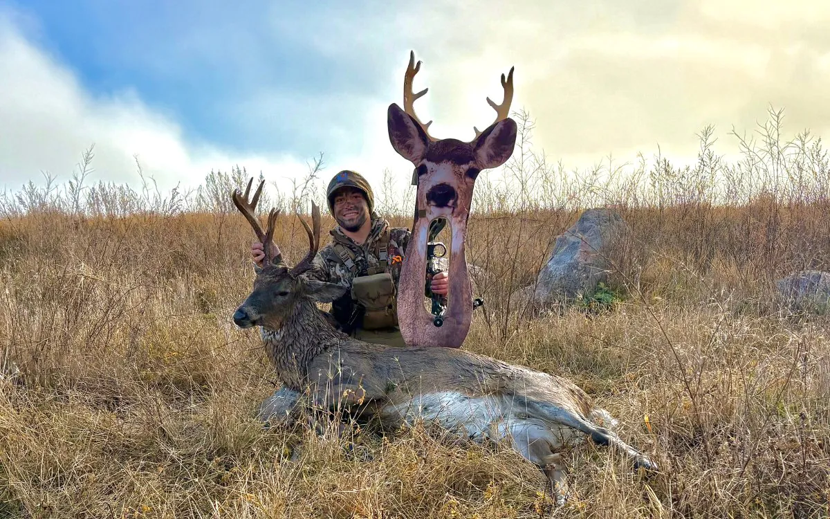 L'auteur avec un cerf de Virginie dans la prairie tout en brandissant son arc et son leurre.