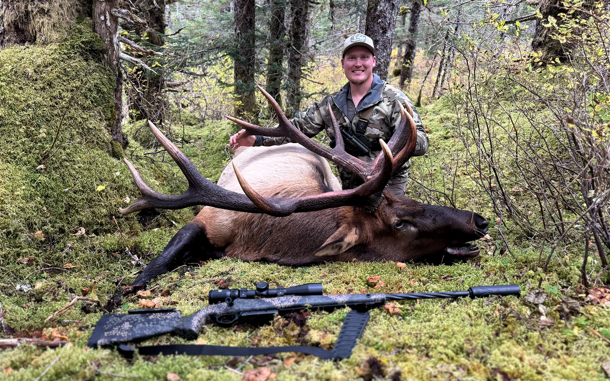 Un chasseur avec un wapiti mâle marqué sur l'île Afognak en Alaska.