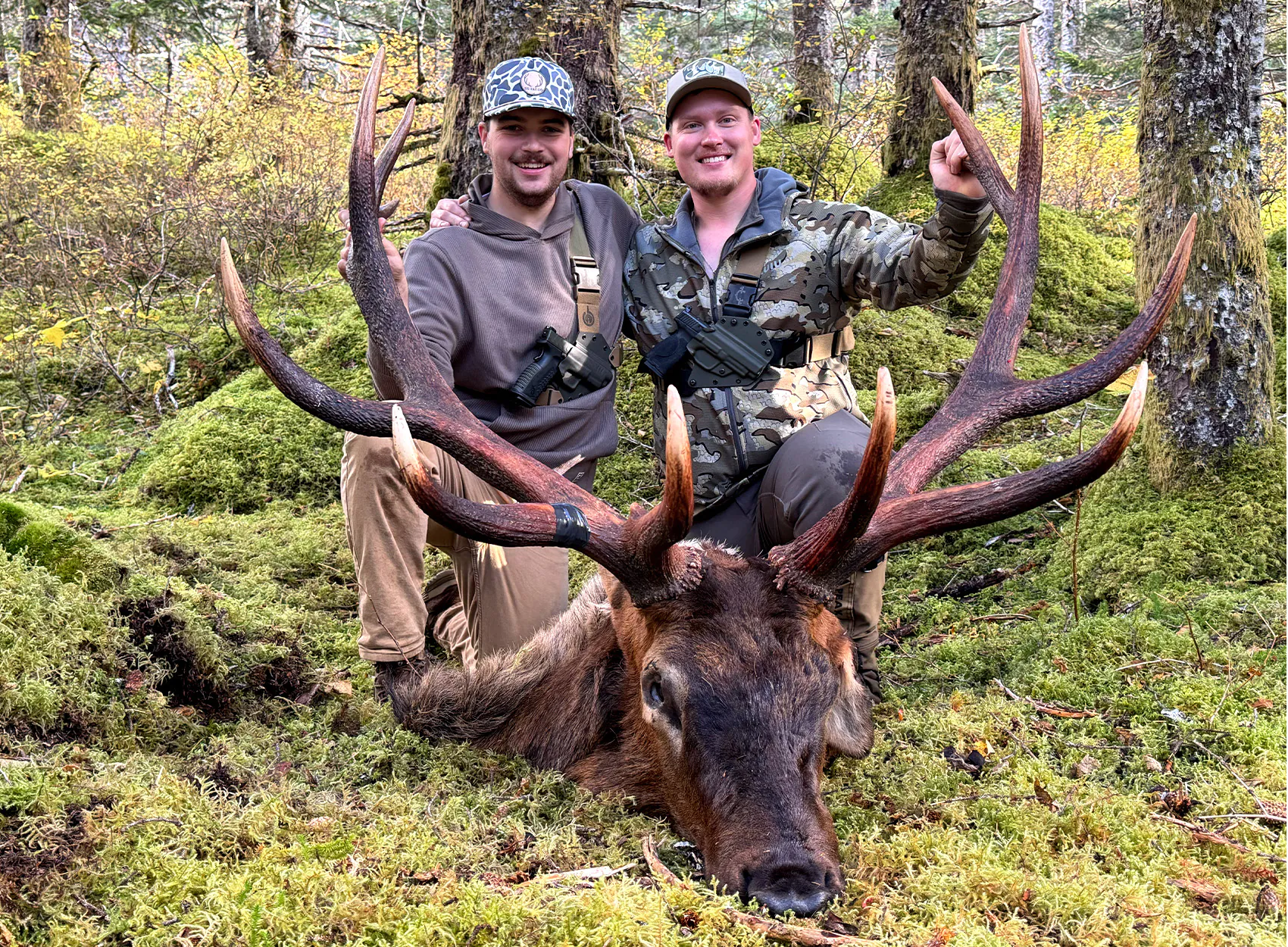 Deux chasseurs avec un énorme wapiti mâle Roosevelt.