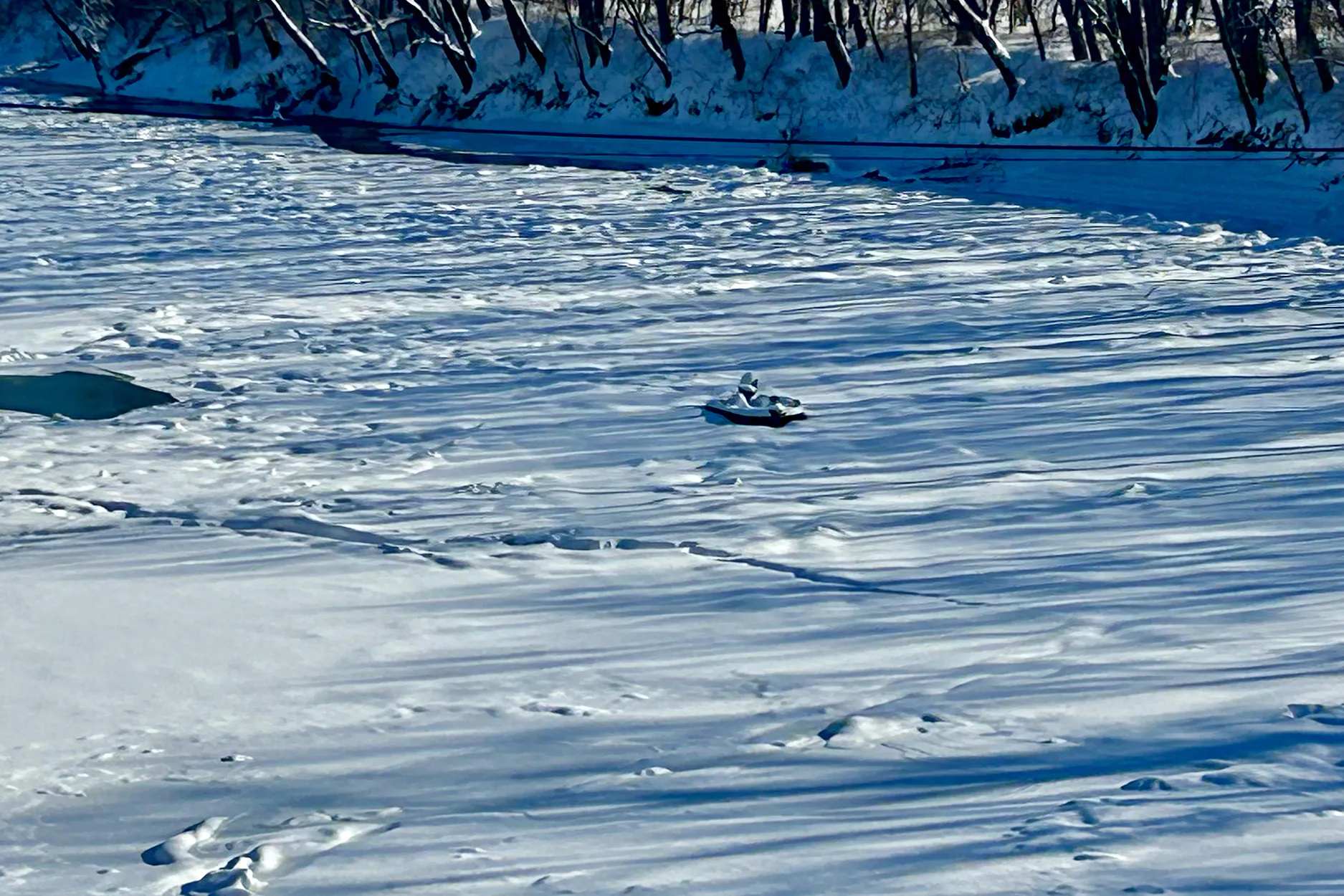 Un bateau-jonc coincé dans une rivière gelée.