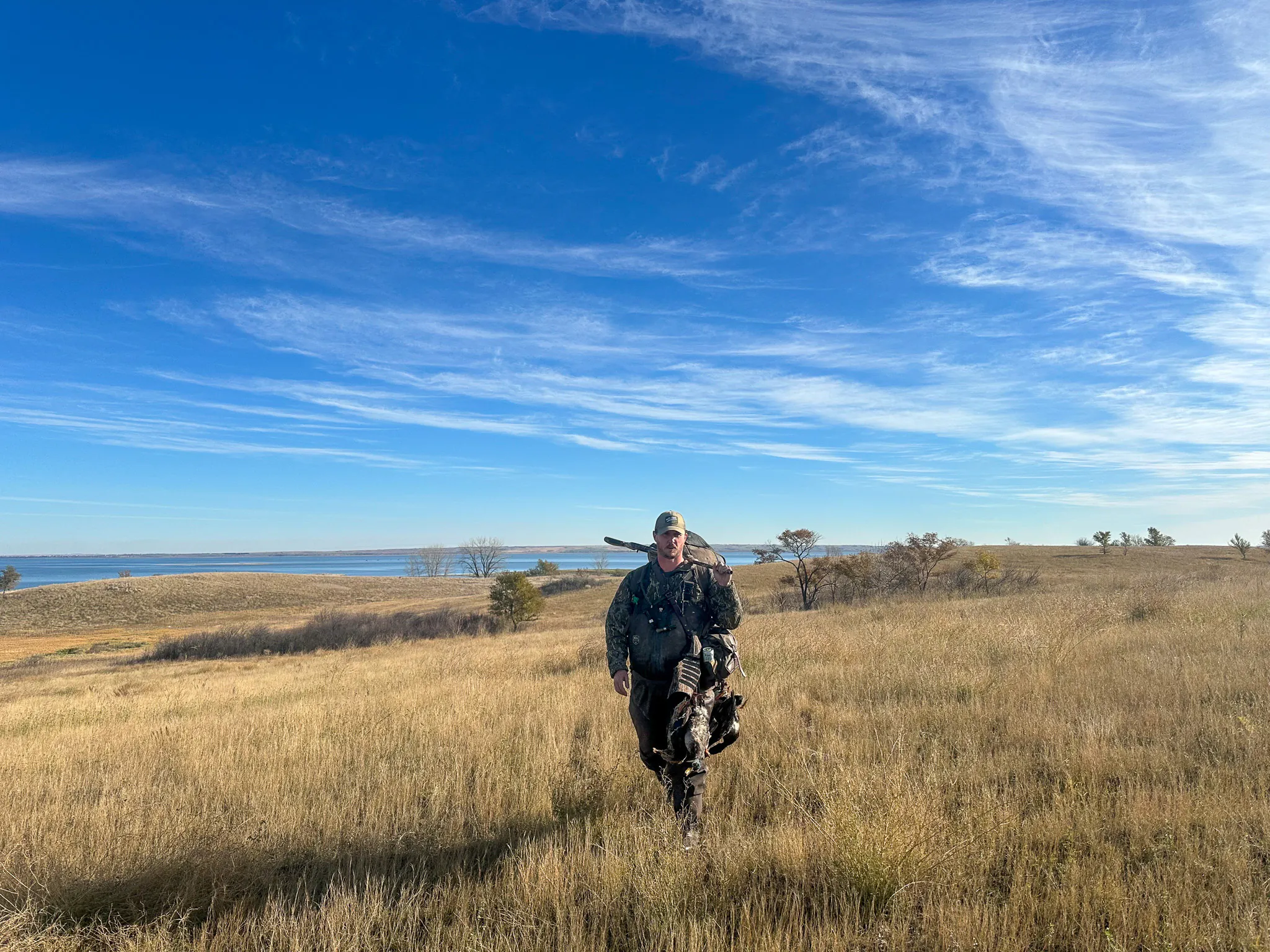 Un chasseur de canards traverse un grand champ.