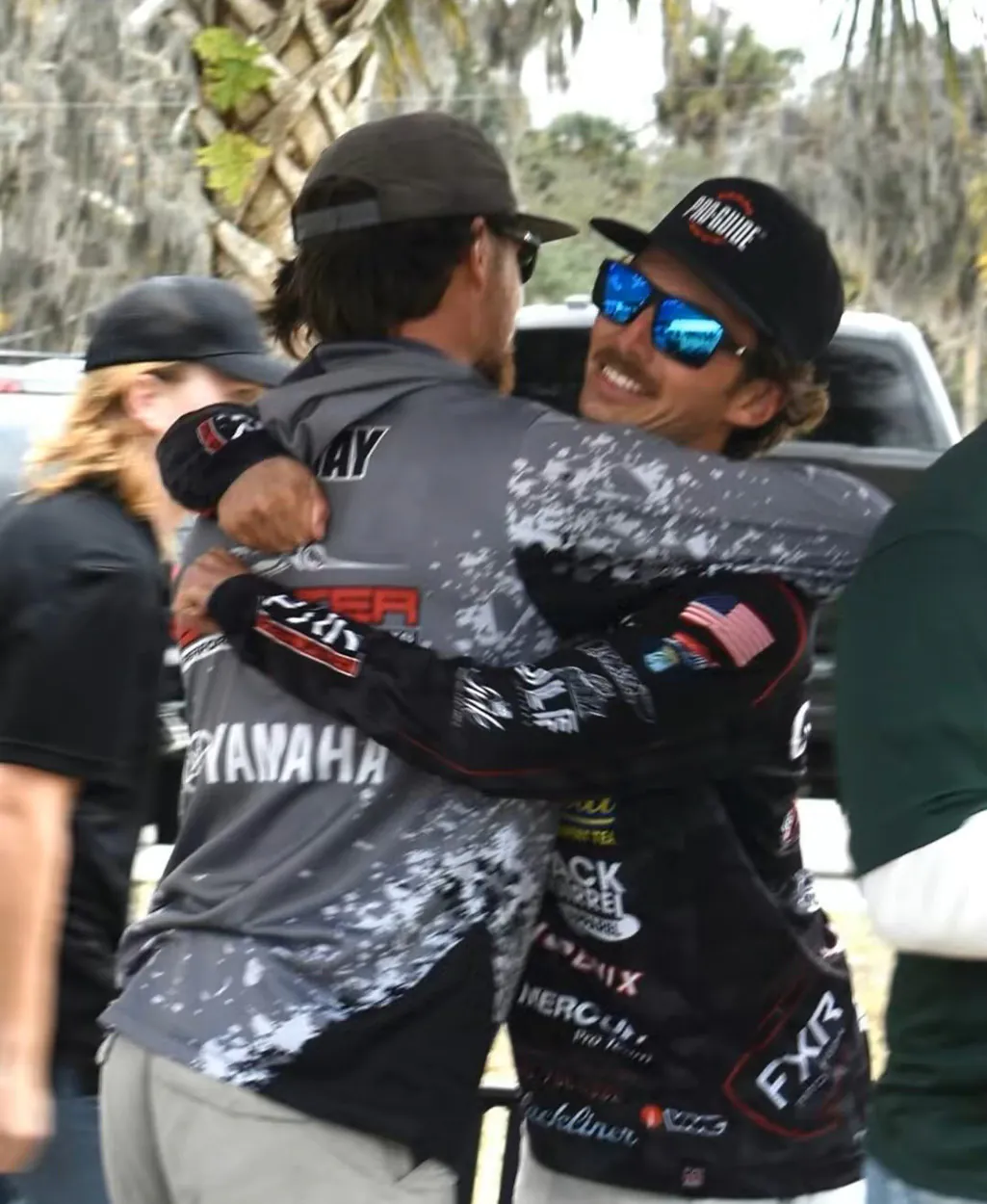 Deux pêcheurs s'embrassent lors d'un tournoi de basse en équipe.