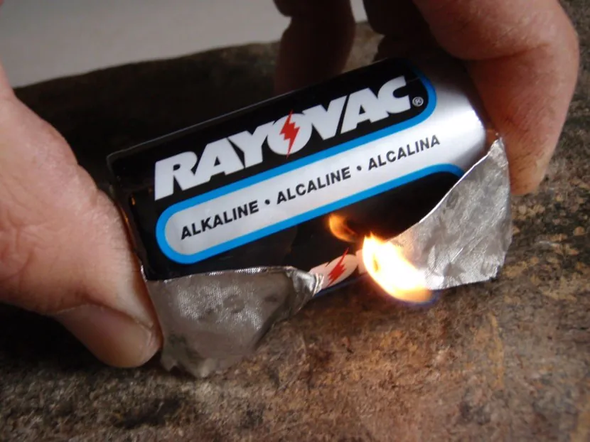 Allumer un feu avec un emballage de gomme et une pile.