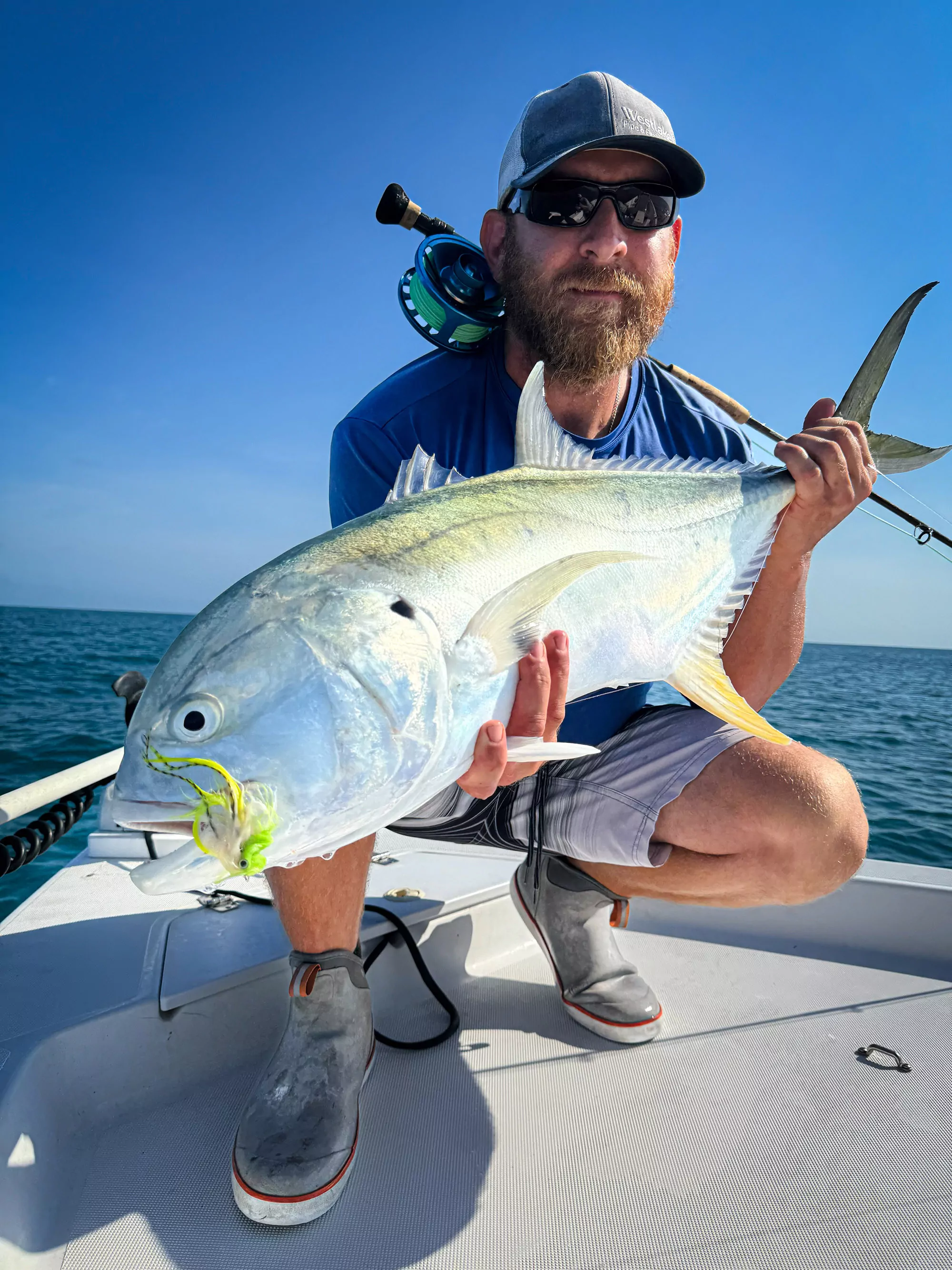 Un pêcheur à la mouche avec une crevalle.