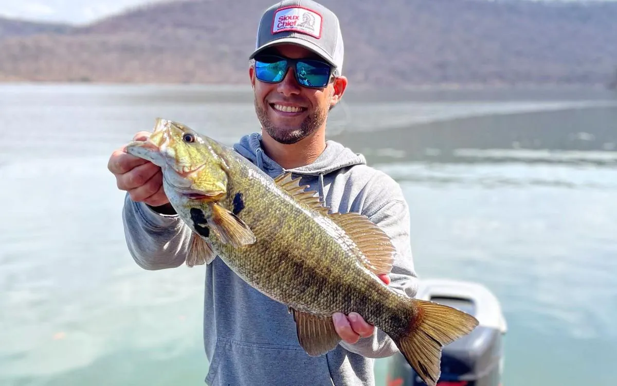 L'auteur brandit un achigan à petite bouche qu'il a capturé avec un spinnerbait.