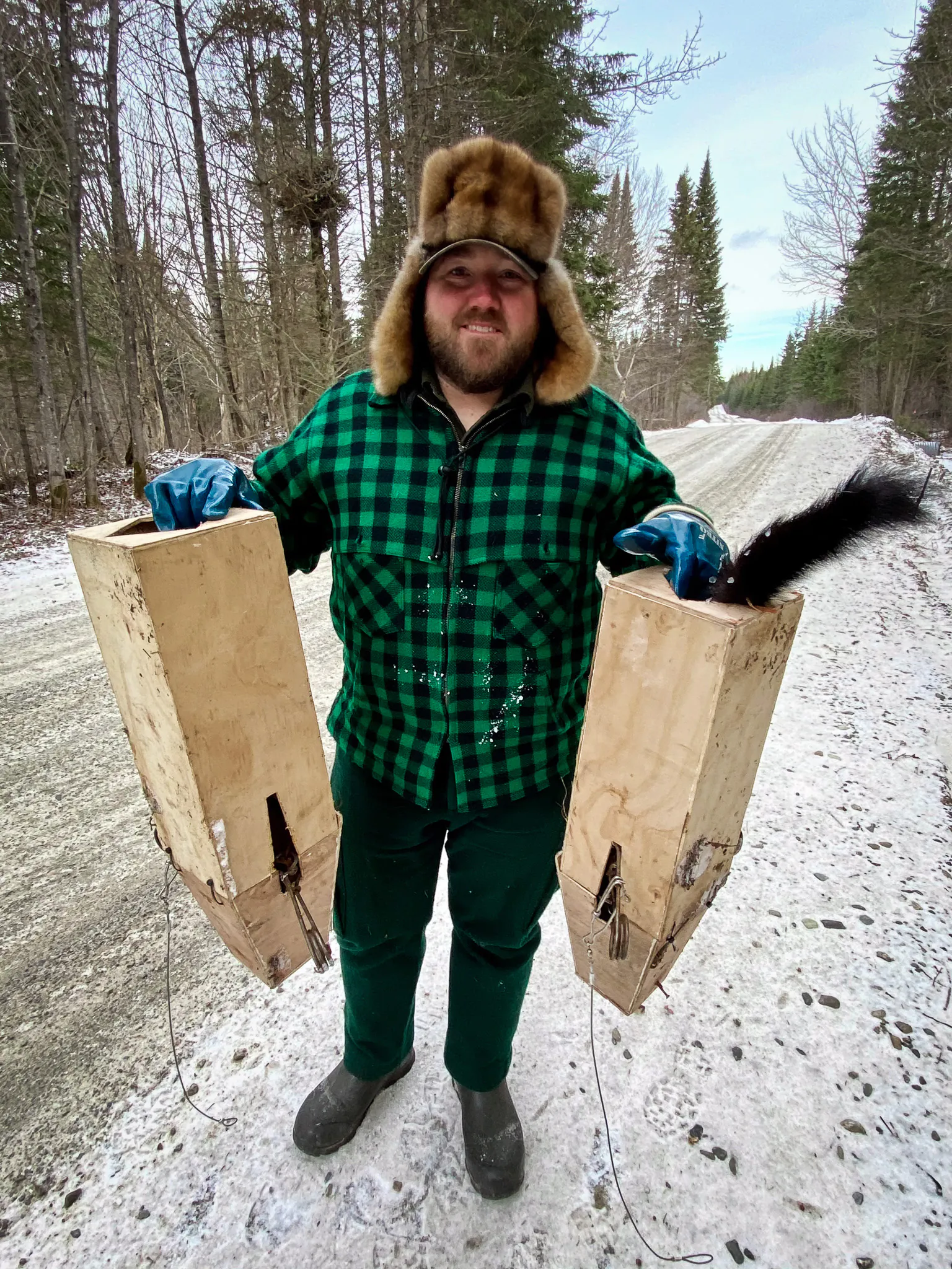 Un trappeur du Maine avec deux boîtes de piégeage.