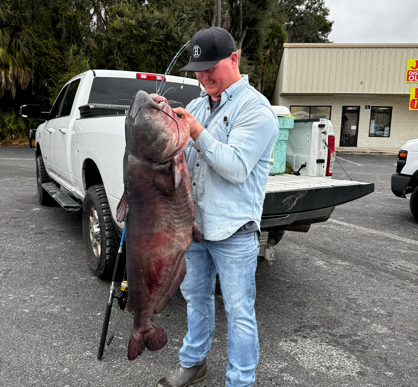 Un pêcheur avec un gros poisson-chat sur une rampe de mise à l'eau en Floride.